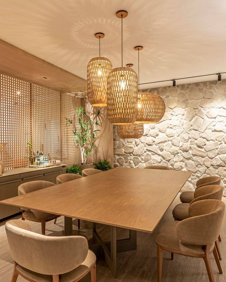 Luminárias biodegradáveis feitas de bambu pendentes sobre mesa de jantar de madeira, com decoração natural e iluminação aconchegante.