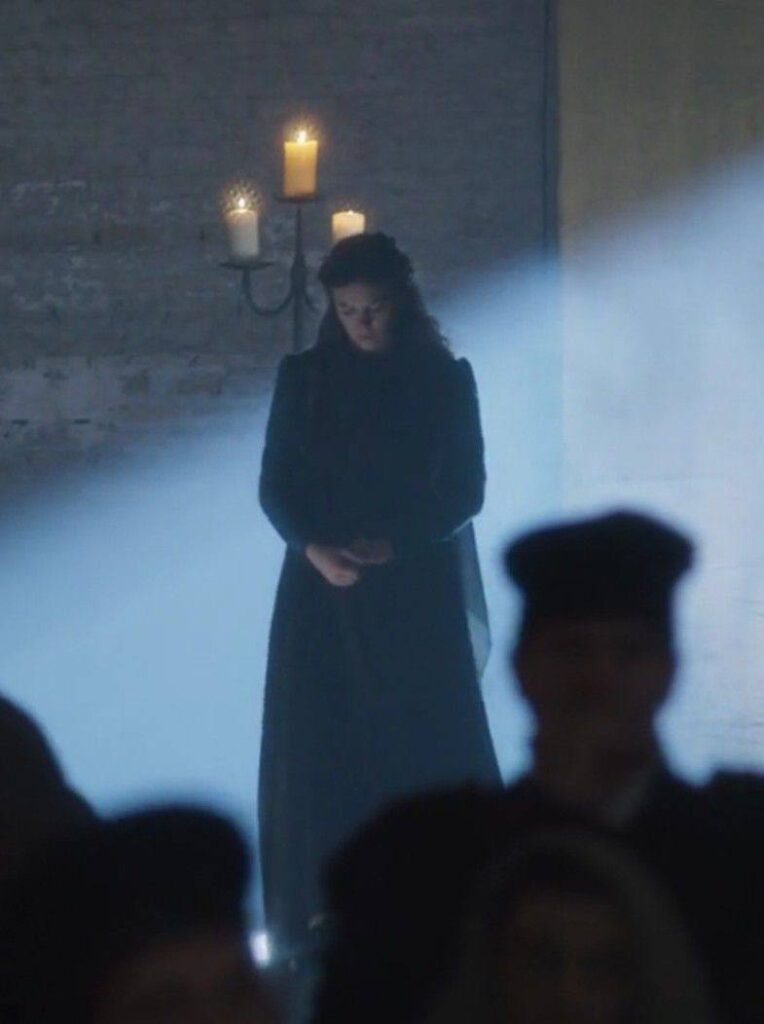 Mulher em um ambiente iluminado por velas, simbolizando reflexão e superação do medo de fracassar.