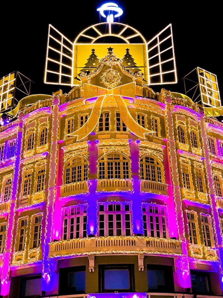 Fachada iluminada do Palácio Avenida no Natal de Curitiba, destacando a cidade como uma das mais tradicionais cidades natalinas do Brasil.
